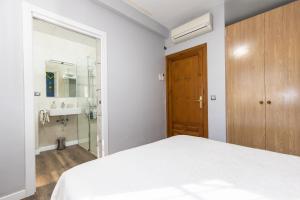 a bedroom with a white bed and a bathroom at Casa Rural Mas ROTAVELLA in Montbrió del Camp +14 photos