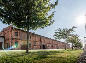 a large brick building with trees in front of it at Penzion Albertovec in Opava