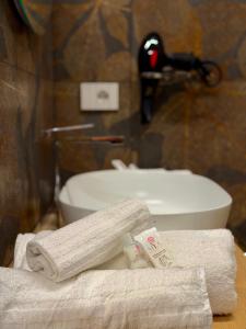 a bathroom with towels and a toilet and a sink at Ludogà Luxury Suite in Trebisacce +10 photos