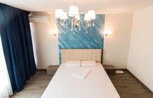 加拉茨的住宿－Zolotko，卧室配有一张带吊灯的大型白色床。