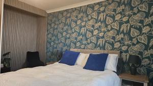 a bedroom with a bed with a floral wallpaper at Talarfor Barmouth in Barmouth