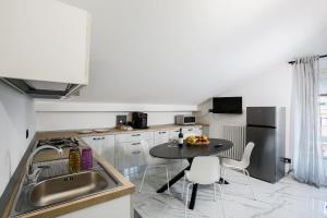 a kitchen with a sink and a table with chairs at La casa delle Langhe in Guarene
