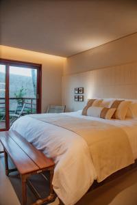 Un dormitorio con una cama grande y un balcón. en Lahaina Hotel, en Amontada