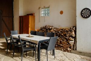 a table and chairs in a room with a pile of fire wood at Chalupa Brumov in Brumov
