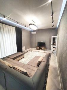 a living room with a couch and a television at Tashkent City Apartments D11 in Tashkent
