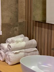 a pile of towels on a table next to a sink at Ludogà Luxury Suite in Trebisacce