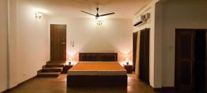 a bedroom with a bed and a ceiling fan at Gruham Homestay in Jorhāt