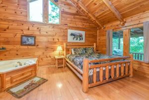 a log cabin bedroom with a bed and a tub at Luxury Cabin • 4 King Beds • Jacuzzi in Each Room in Cartertown +42 photos