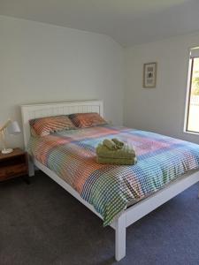 a bed with a stuffed animal on top of it at House in Restful Setting in Whangarei
