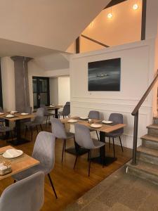 a dining room with tables and chairs and a staircase at Carlo Felice Boutique Hotel in Turin