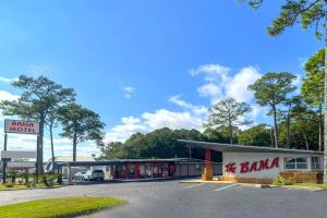 a gas station with a car parked in the parking lot at Bama Motel Mobile I-65 & US-90 in Mobile