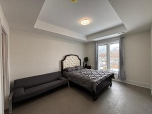 a bedroom with a bed and a couch in it at Cozy Suite in Brand New Luxury Home in Toronto