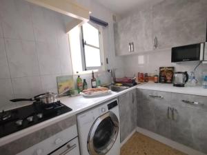 a kitchen with a washing machine and a sink at Apartament Maria F in Mojácar