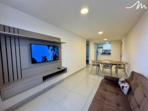a living room with a couch and a flat screen tv at Apartamento com Vista p/o Mar-Cabo Branco in João Pessoa