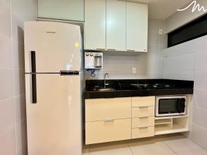 a kitchen with a refrigerator and a microwave at Apartamento com Vista p/o Mar-Cabo Branco in João Pessoa