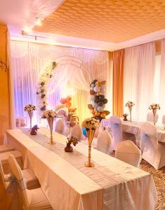 a room with a long table with white tables and chairs at Pension Waldau in Kassel