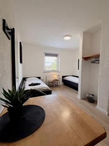 a bedroom with a bed and a plant on a wooden floor at Pension Bockenem Extra in Bockenem