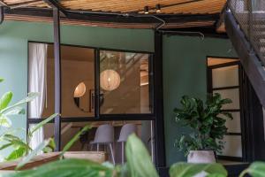 a room with glass doors and plants at The Box by Wynwood House in El Salvador