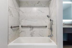 baño con bañera blanca y pared de mármol en Red Lion Inn & Suites Lemoore, en Lemoore 14 fotos más