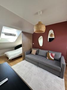 a living room with a couch and a bed at Le precieux de la Gare in Saint-Pierre-des-Corps