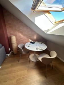 a table and chairs in a room with a window at Le precieux de la Gare in Saint-Pierre-des-Corps