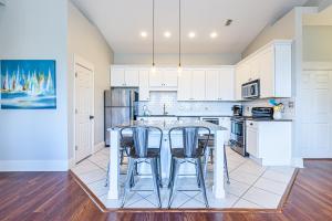 una cucina con mobili bianchi, tavolo e sedie di Topsail Village 824 a Santa Rosa Beach