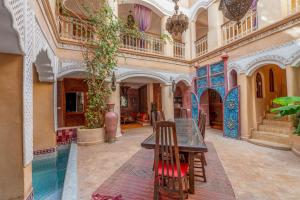 a room with a table and chairs in a building at Riad Lorsya in Marrakech