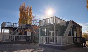 a house with two decks with the sun behind it at Page Lake Powell Campground - Tiny Homes in Page