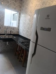 a kitchen with a refrigerator and a counter with a sink at Espaço jr in Andradina
