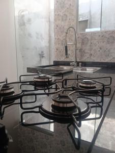 a stove top in a kitchen with a sink at Espaço jr in Andradina