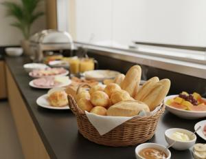 a table with a basket of bread and plates of food at Acqua Di Mare Pousada in Itanhaém +18 photos