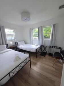 西棕榈滩Cozy 3BR WPB Cottage的带两张床和两个窗户的房间