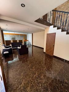 an empty living room with a staircase and a living room at Modern, comfortable and convenient space in Sucre