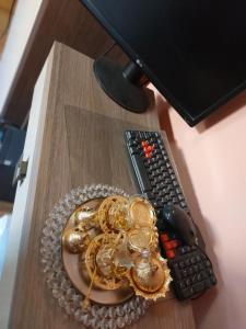MiroslavaにあるDoraのコンピューターモニターの横の机の上に金の宝石が飾られた皿が置かれている
