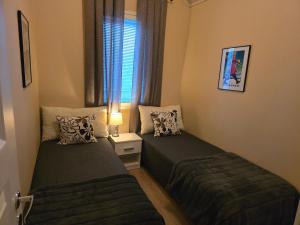 two beds in a small room with a window at Villa IRIS 4, Himos in Jämsä