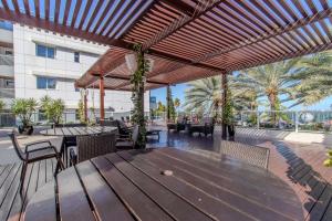 a patio with a wooden table and chairs at Flat à beira-mar Solar Tambaú - MyFlats in Tambaú