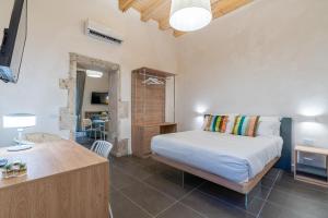 a bedroom with a bed and a desk in a room at Hotiday Apartments Siracusa in Syracuse