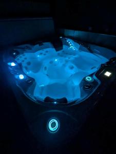 una vasca idromassaggio blu con luci in una stanza buia di Gite de campagne avec SPA privatif a Saint-Sauvant