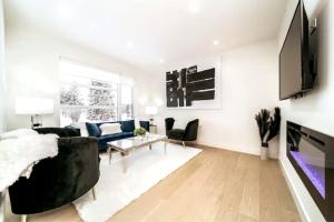 a living room with a couch and a tv at 5BDRM Chic Modern Home-Hot Tub-King Bed-AC-Garage in Edmonton