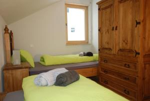 a bedroom with two beds and a dresser and a window at Feriendorf Uorsin in Scuol