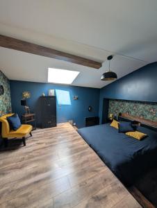 Un dormitorio con una cama grande y una silla amarilla. en Gite de campagne avec SPA privatif, en Saint-Sauvant