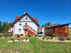a house with a bench in the yard at Apartmány Louka in Vaclavov u Bruntalu