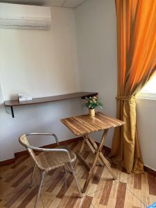 a wooden table and a chair in a room at Hostal Shaddai in Manta