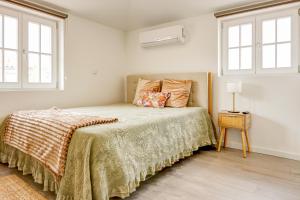 a bedroom with a bed and two windows at Elegant City House Moderno no Centro da Cidade in Chaves +20 photos