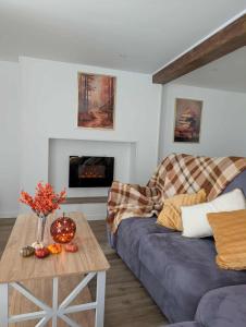 una sala de estar con un sofá y una mesa en Gite de campagne avec SPA privatif, en Saint-Sauvant