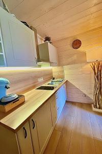 a kitchen with wooden cabinets and a sink in a cabin at L écrin vosgien in La Bresse