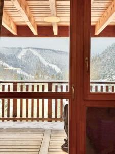 a door to a balcony with a view of the mountains at L écrin vosgien in La Bresse