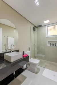 a bathroom with a sink and a toilet and a shower at Vilinha típica - Suíte Onze Tuin - Entrada com senha - Somos hospedagem por temporada in Holambra +69 photos