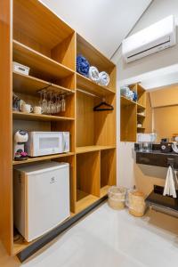 a kitchen with wooden cabinets and a refrigerator at Vilinha típica - Suíte Onze Tuin - Entrada com senha - Somos hospedagem por temporada in Holambra