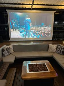 Ein großer Bildschirm mit einer Menge Leute, die ein Konzert sehen in der Unterkunft Villa Santa Luz in La Pradera